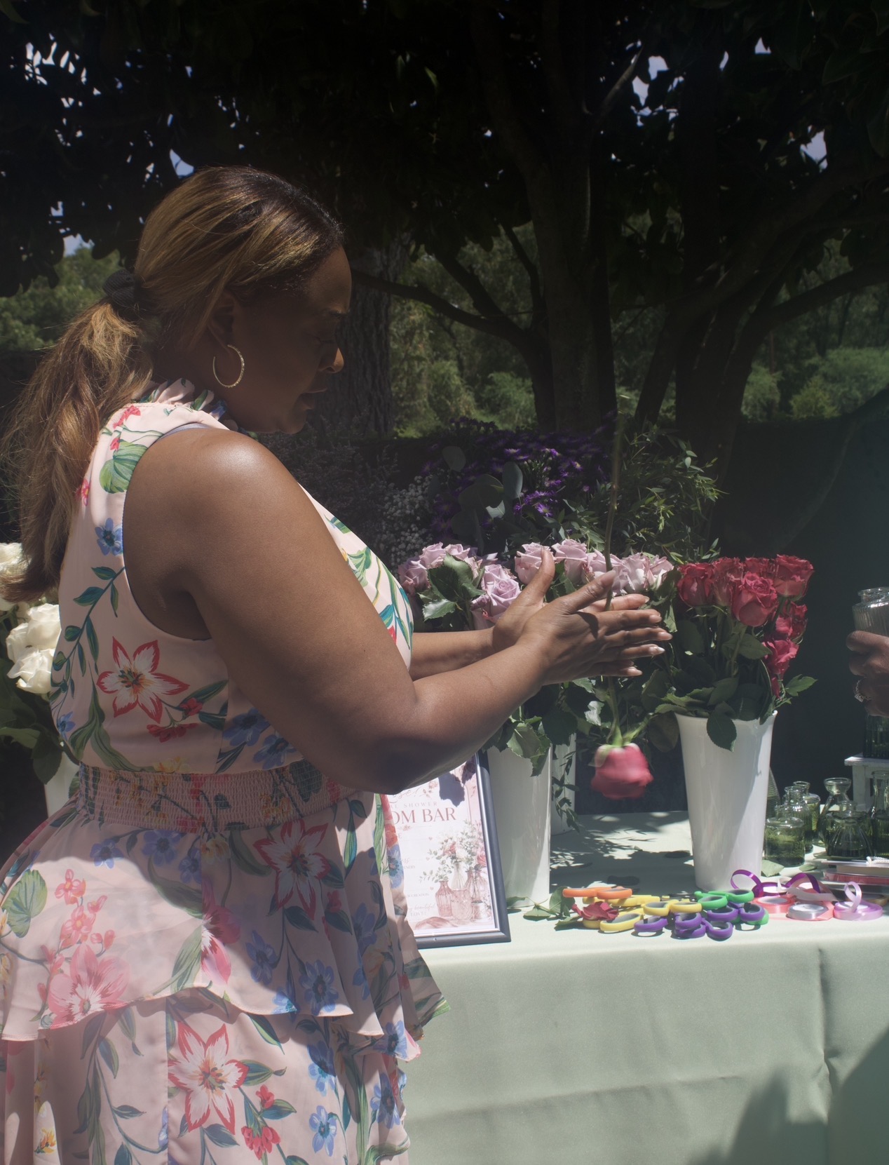 Buzz & Blossoms host showing guests how to gently roll a rose to open the bloom